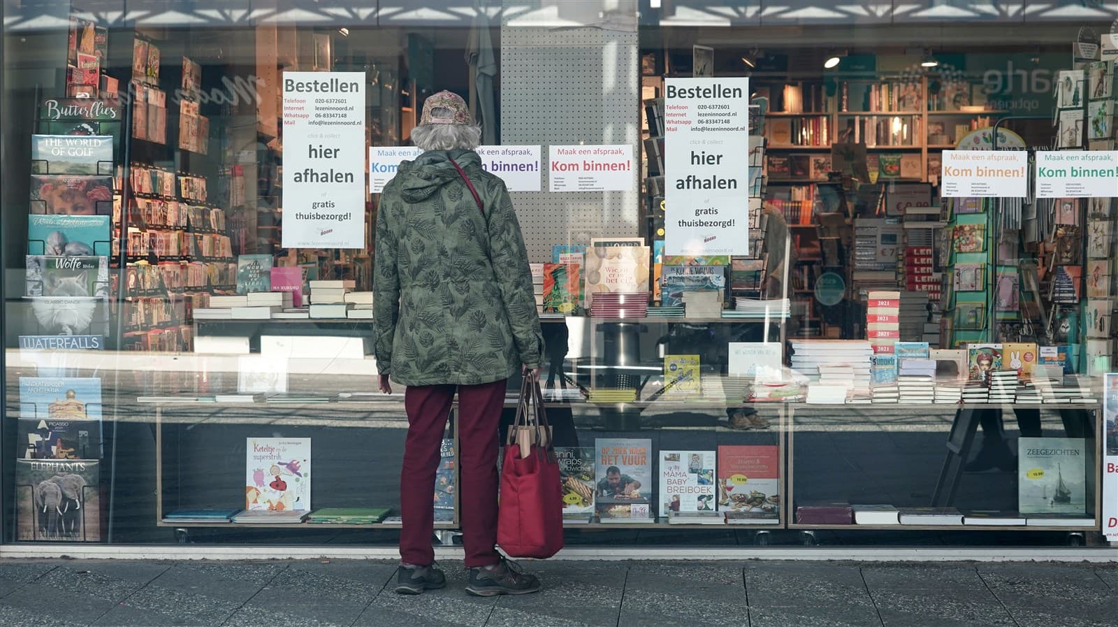 Iemand kijkt in de etalage van een boekwinkel in Noord.